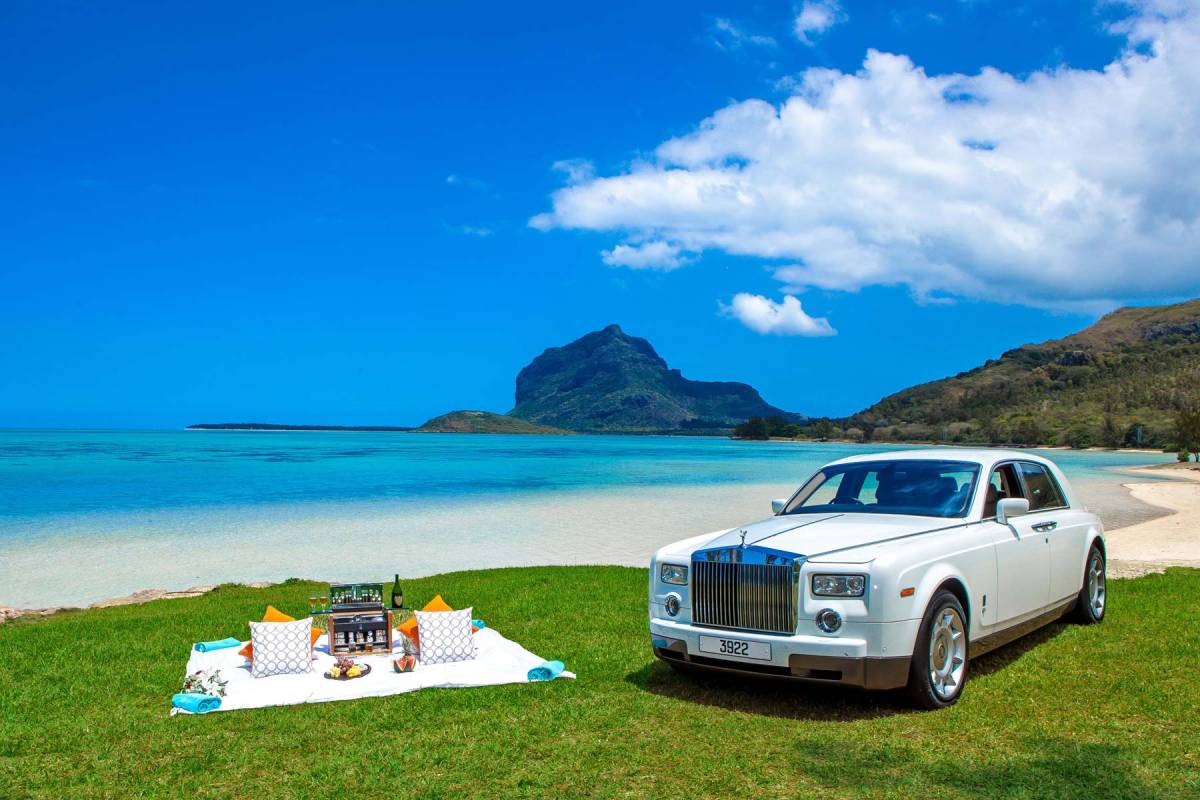 Picknick blanket at the beach besides a Rolls Royce